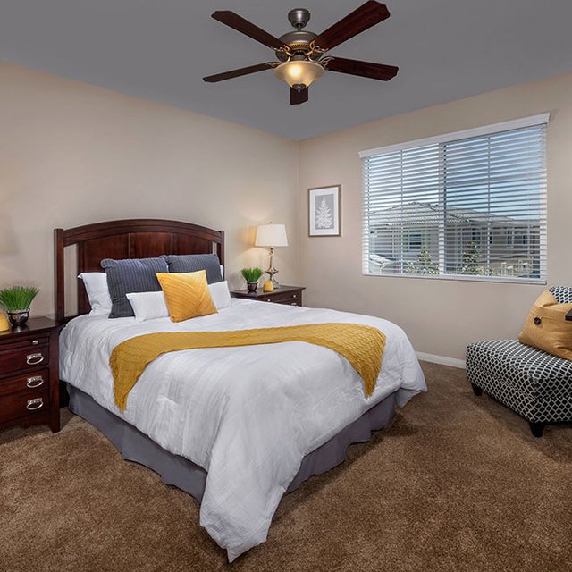 Homecoming at the Preserve Apartments - Bedroom with striped couch